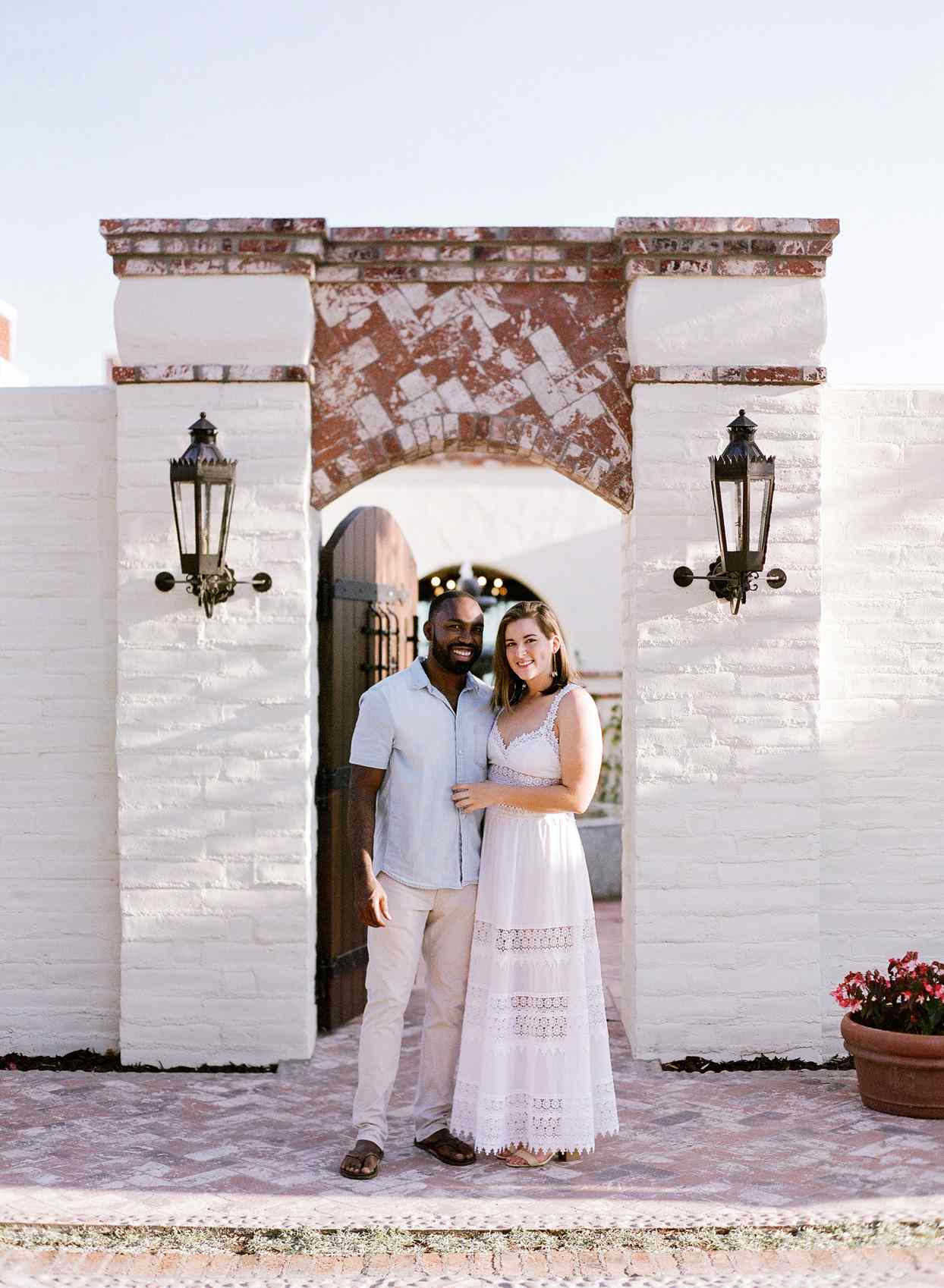 bride and groom to-be smiling outside wedding rehearsal dinner venue