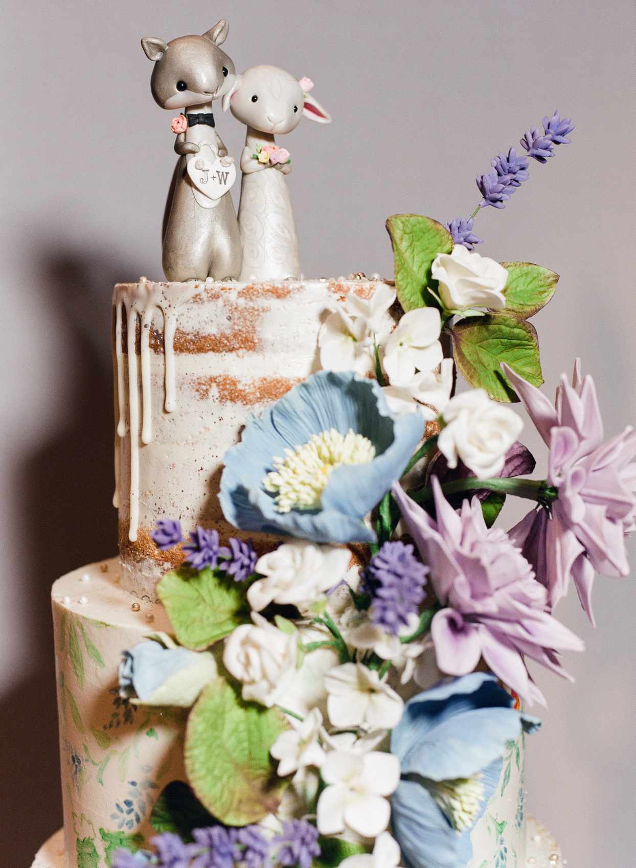 wedding cake topped with squirrel and lamb figurines