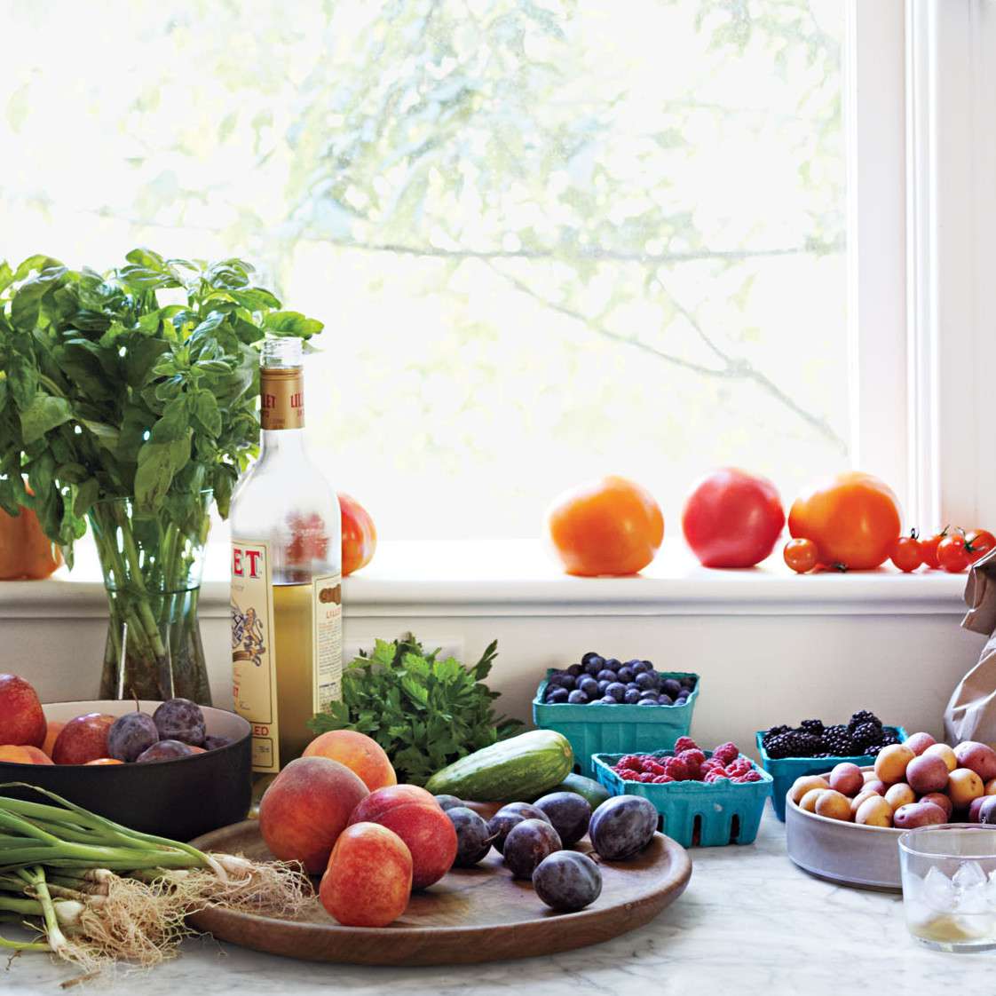 Fruits and vegetables on kitchen counter and window ledge