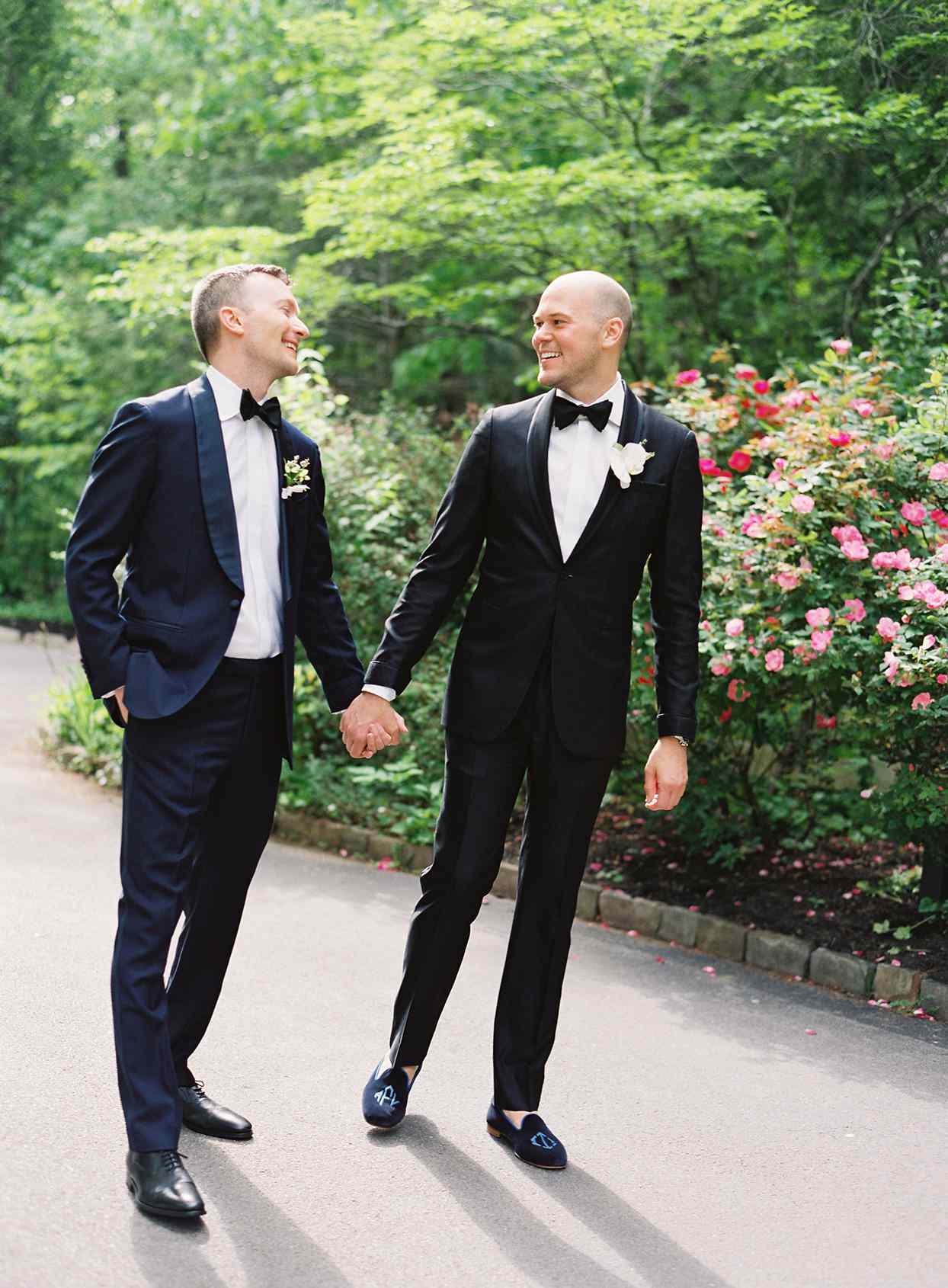 wedding grooms holding hands during portraits