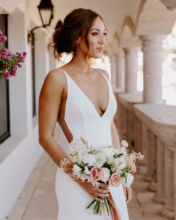 bride holding pastel bouquet on elegant balcony
