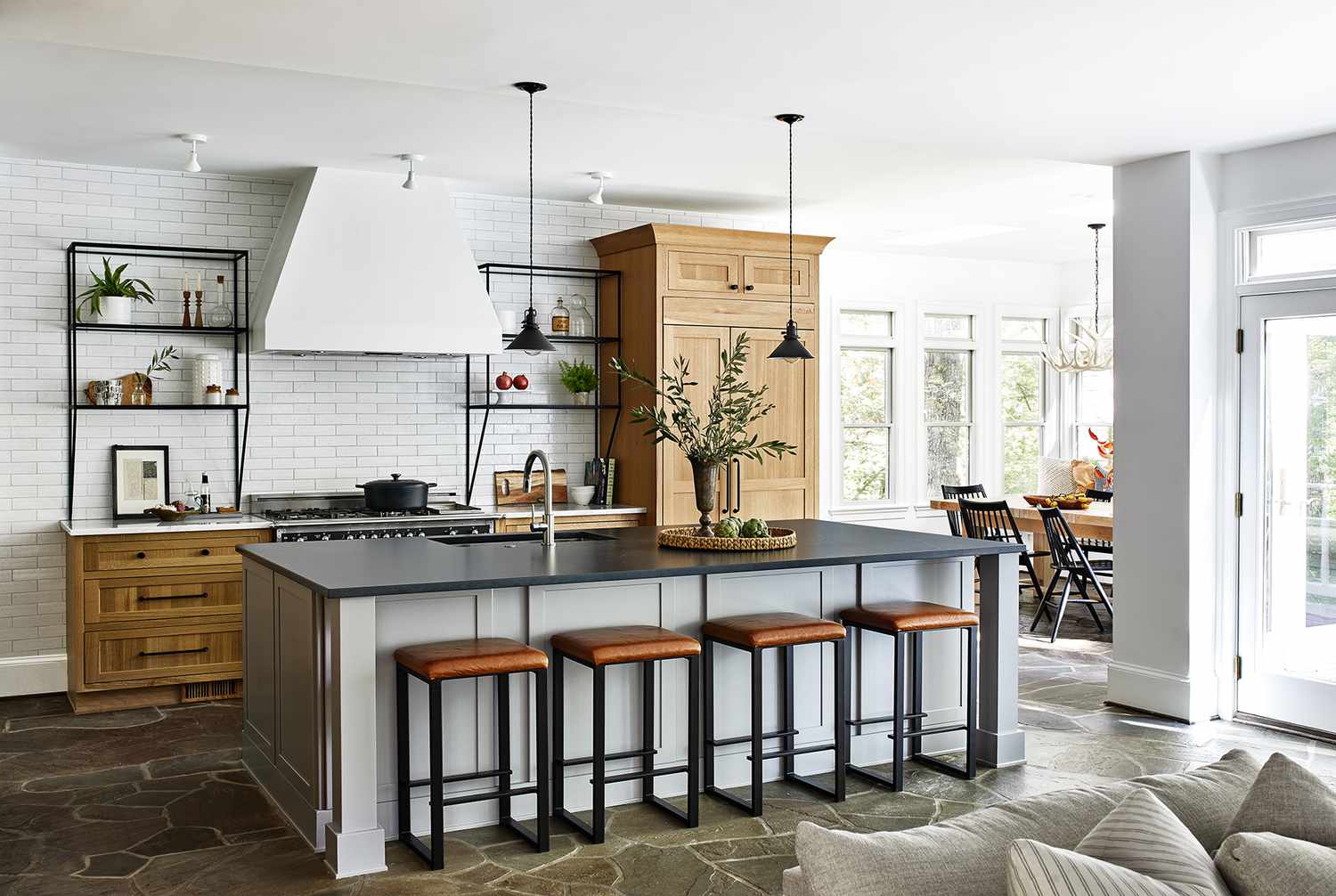 宽敞的开放式厨房，白色墙壁，黑色台面和浅色木材
