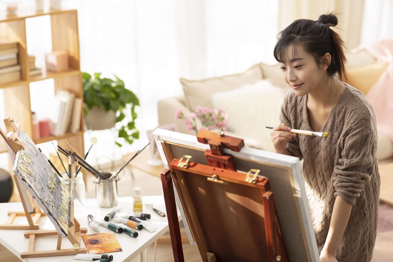 young woman painting at home
