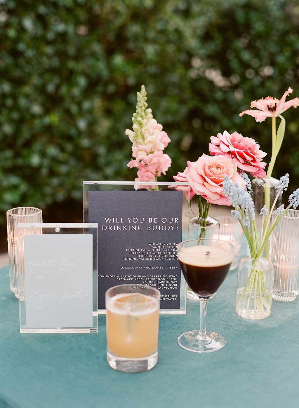 wedding cocktails on table with flowers and sign
