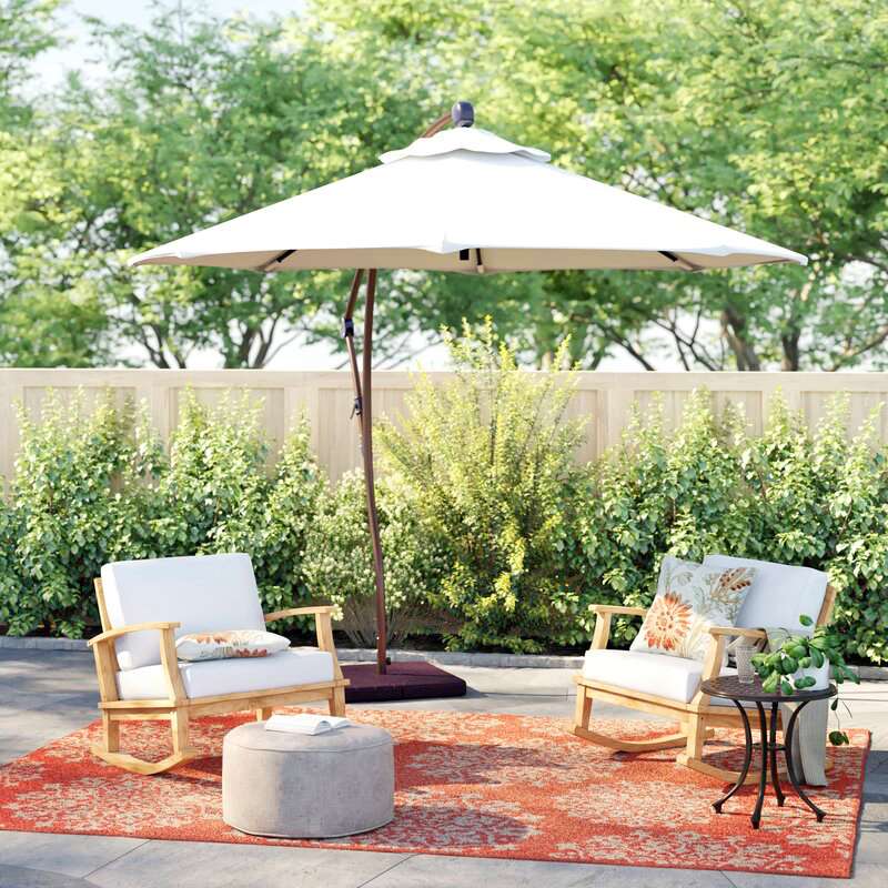 backyard patio seating area with rug and umbrella