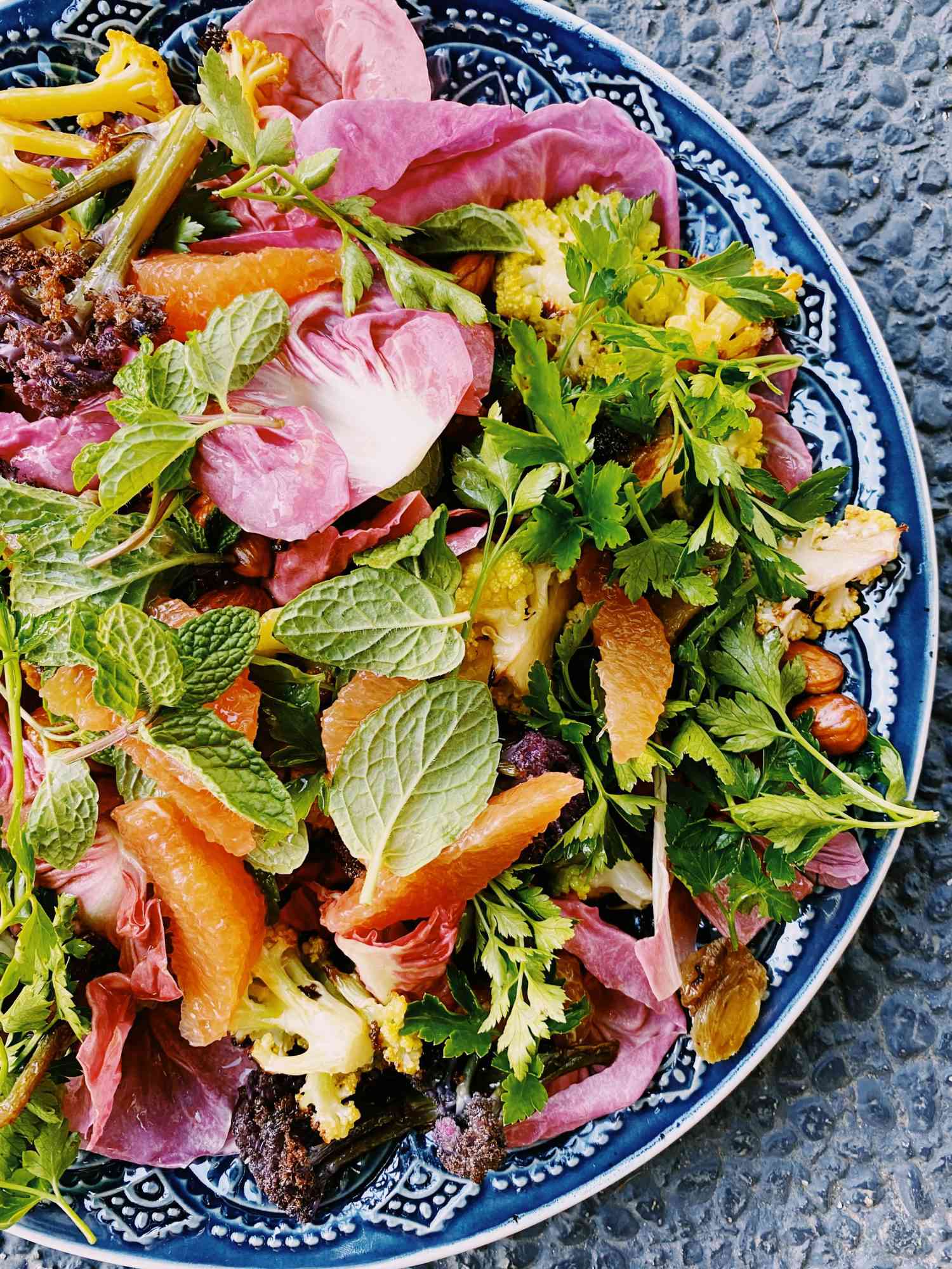 colorful salad with herbs on blue-and-white-plate
