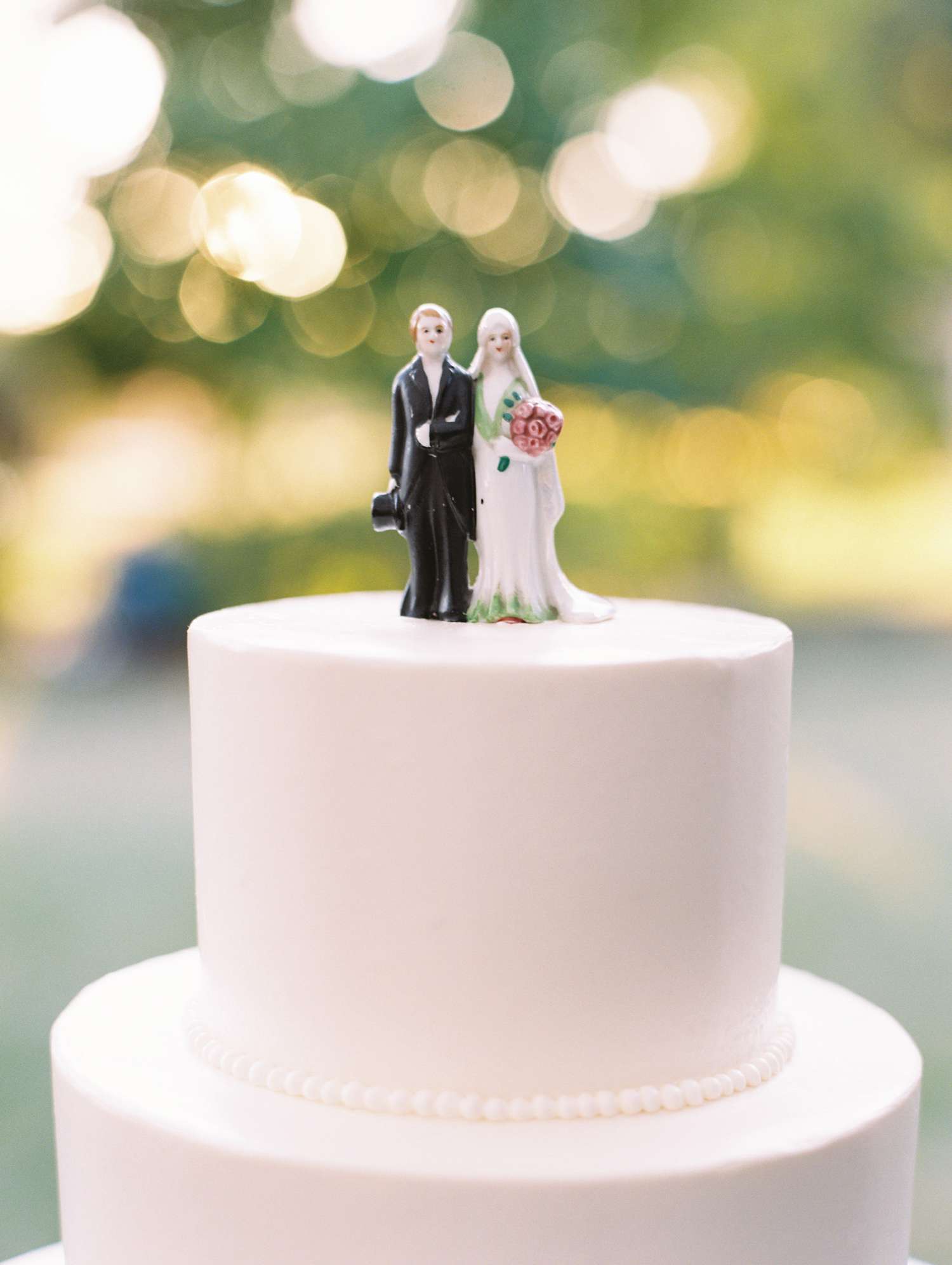 top tier of white wedding cake bride and groom topper