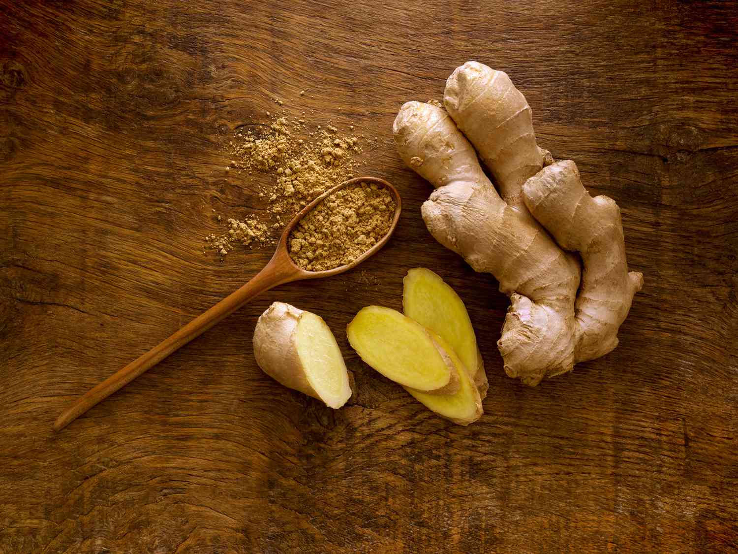 ginger root and wooden spoon with powdered ginger