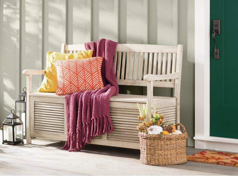 storage bench with pillows and knit blanket