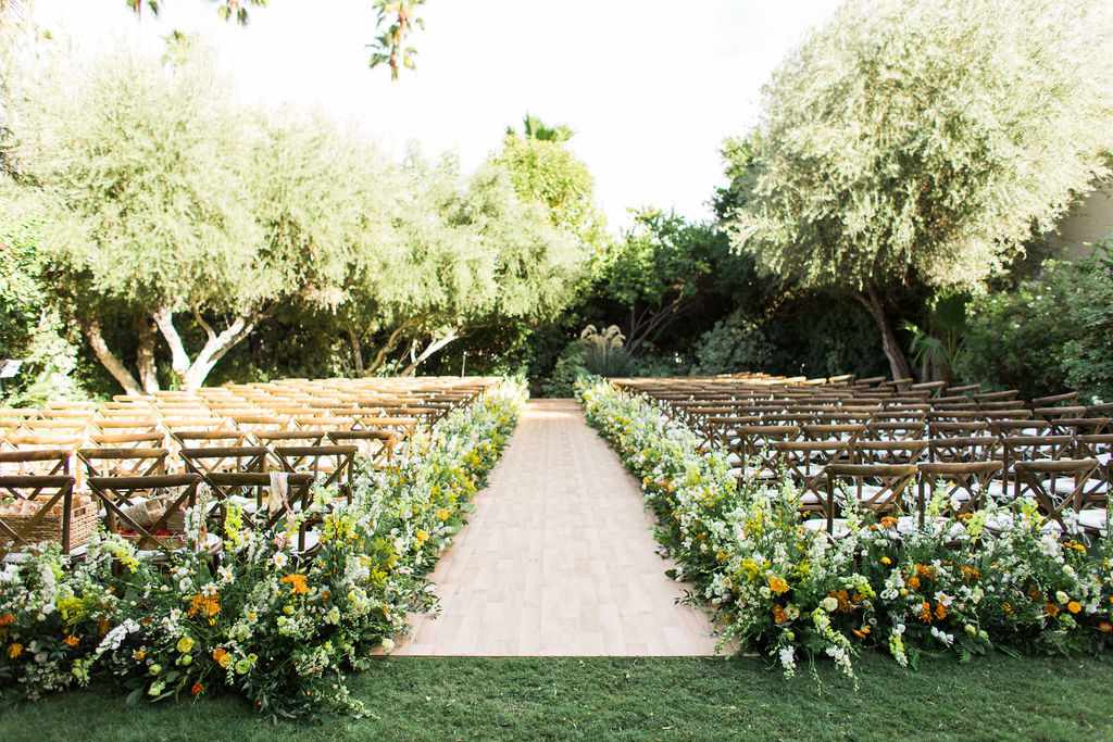 wedding ceremony outdoor space set up with chairs and tree backdrop
