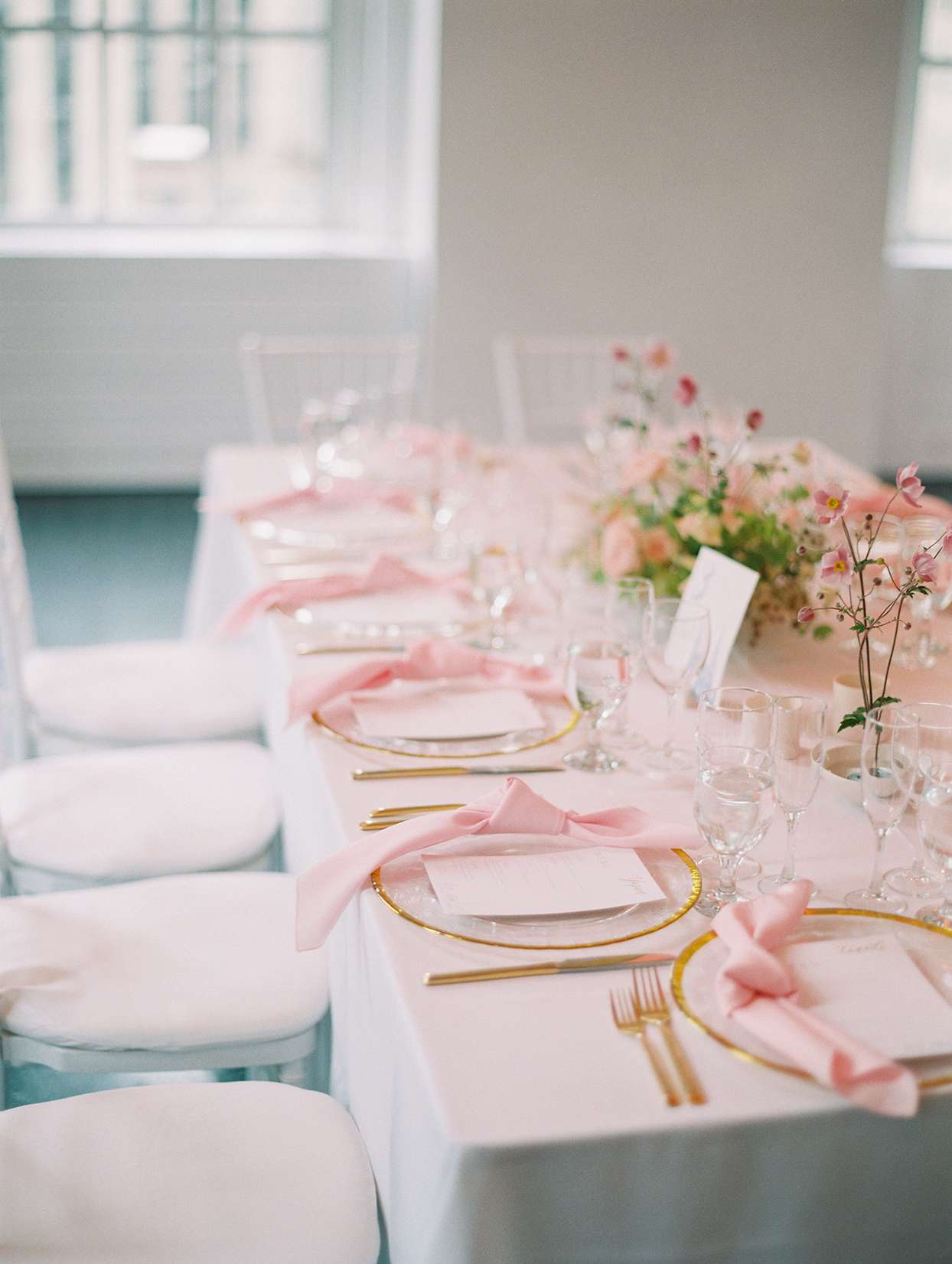 pastel pink and gold wedding place settings at long tables