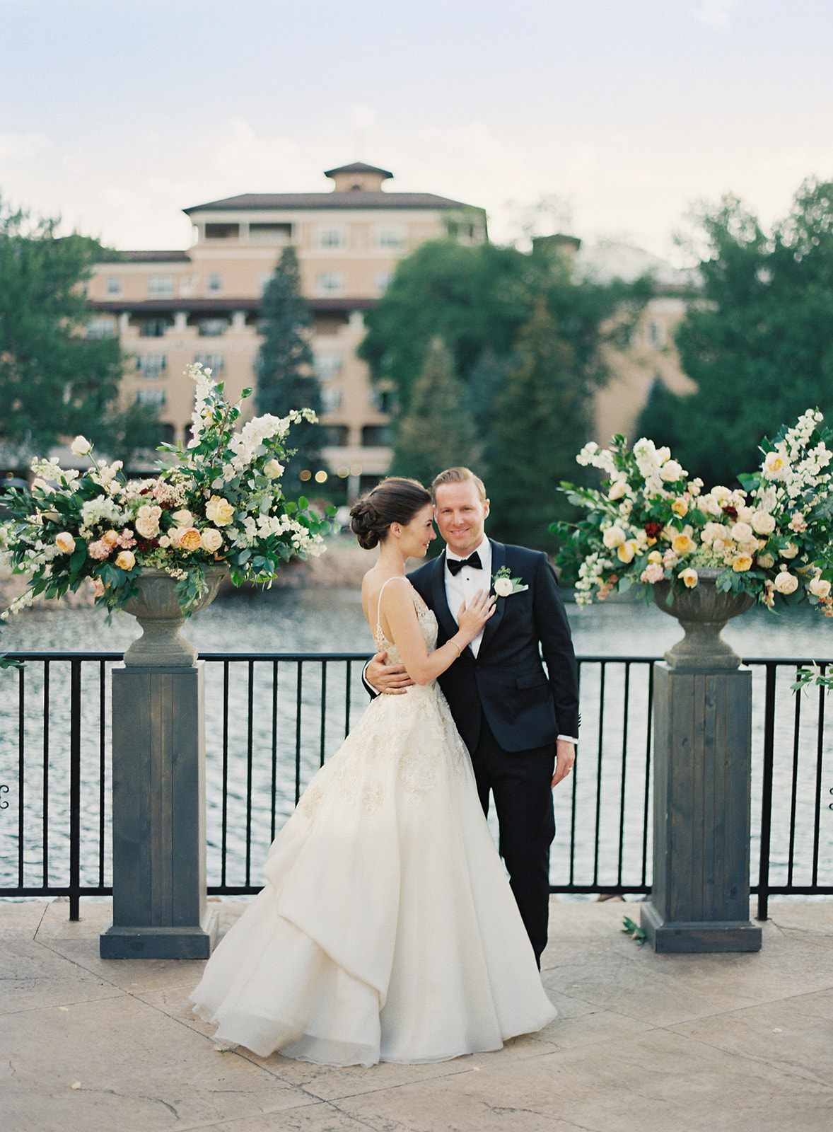 bride and groom outdoor terrace between floral urns