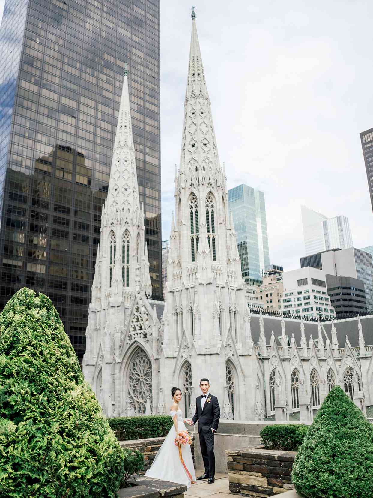 wedding couple posing on rooftop in front of cathedral