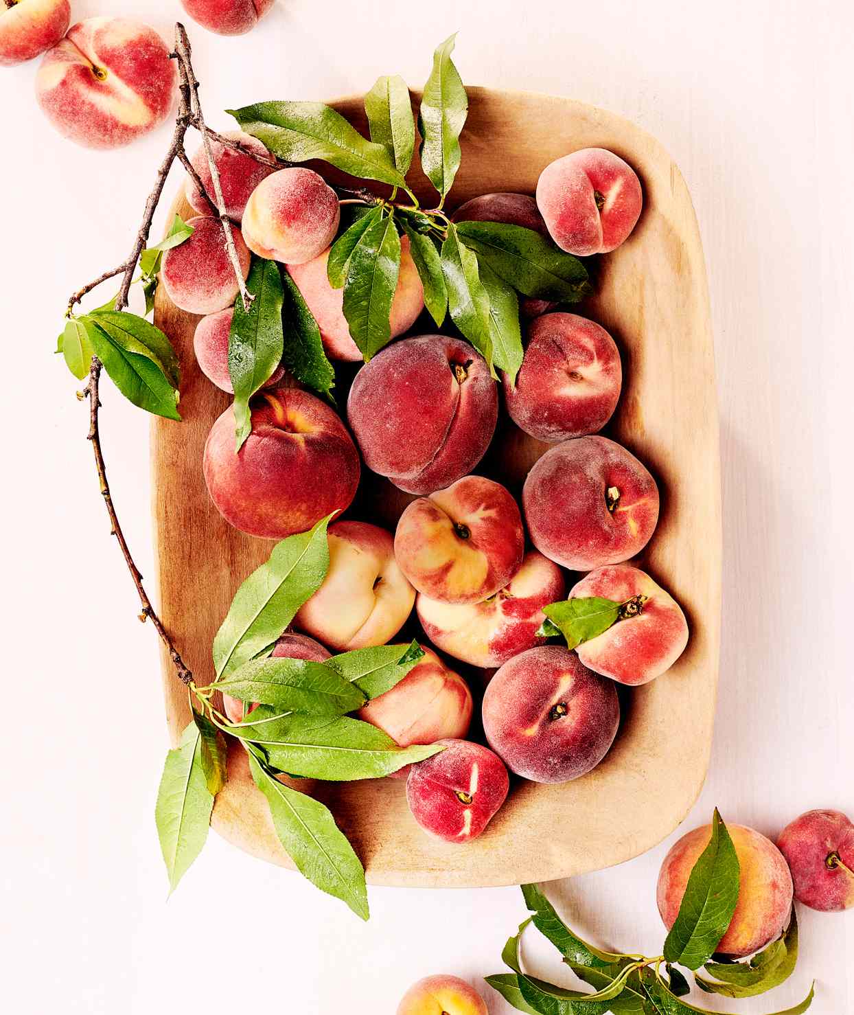 wooden bowl filled with peaches