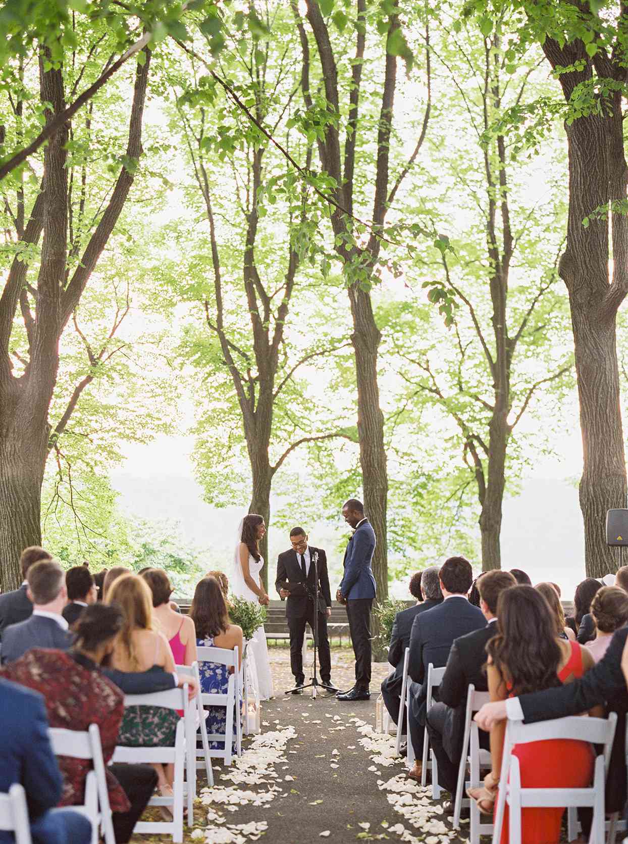 outdoor woodsy wedding ceremony couple smiling with officiant