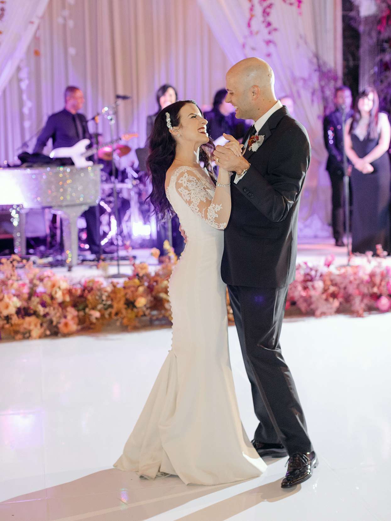 wedding couple first dance in ballroom under purple lights