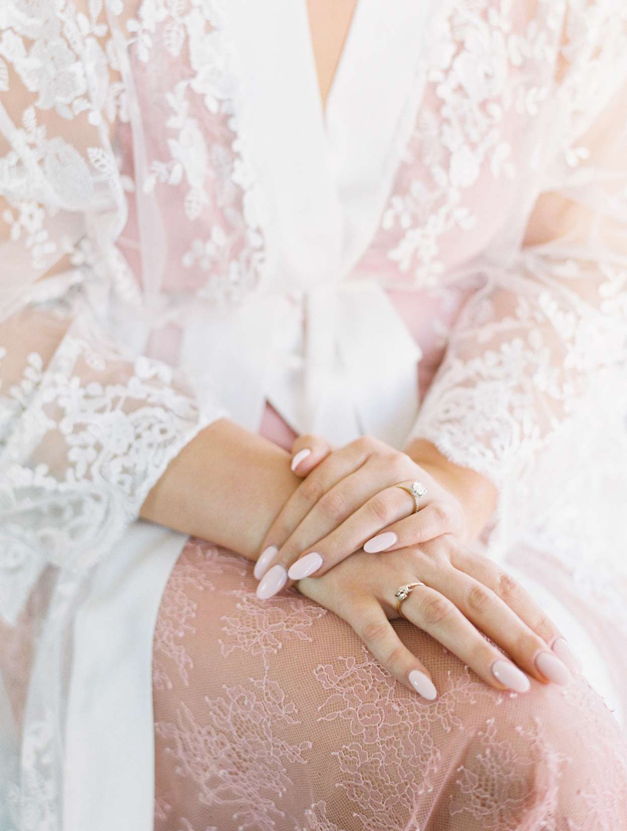bride wearing lace robe with baby pink nails