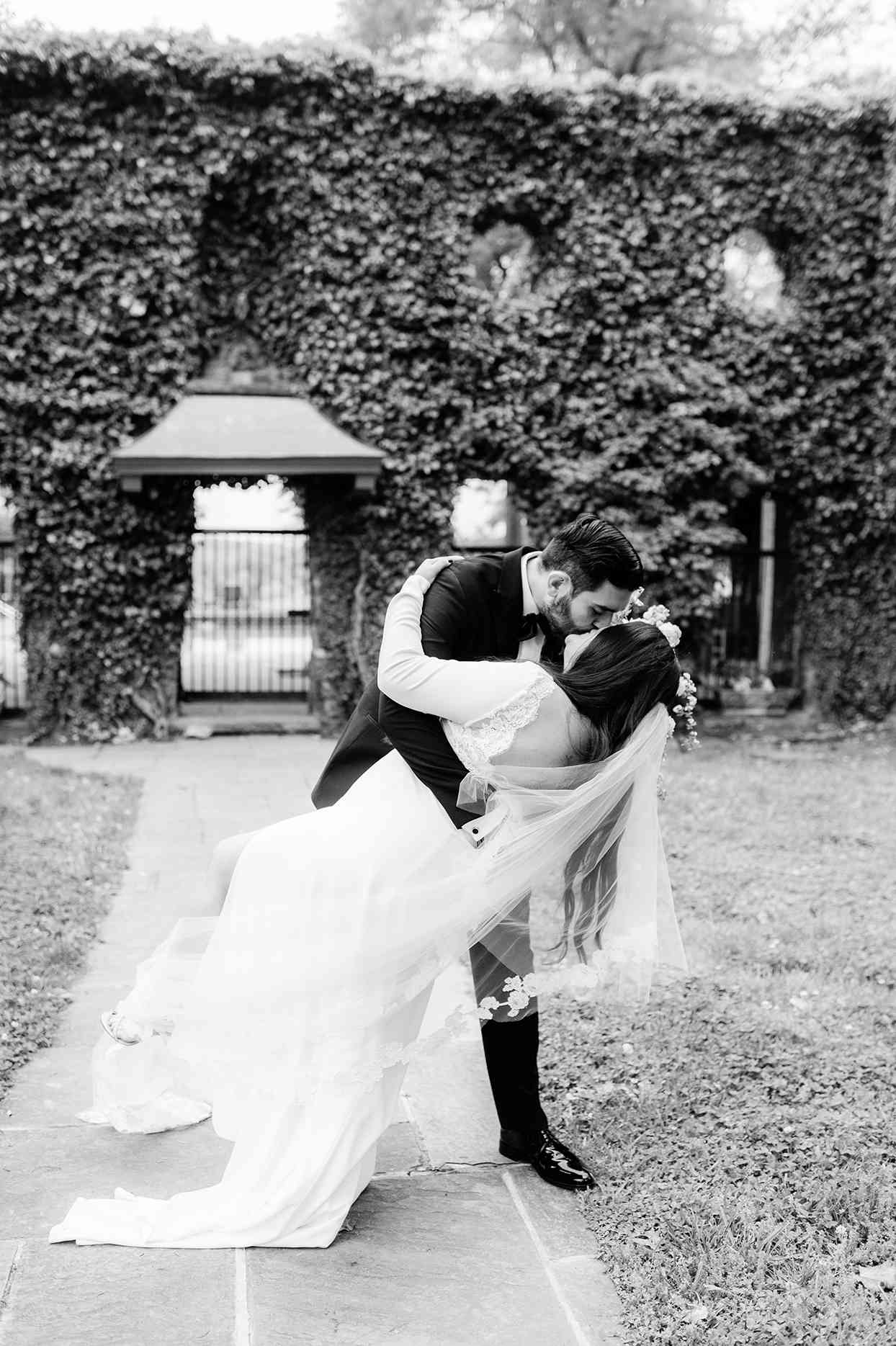 Bride and groom kissing in garden