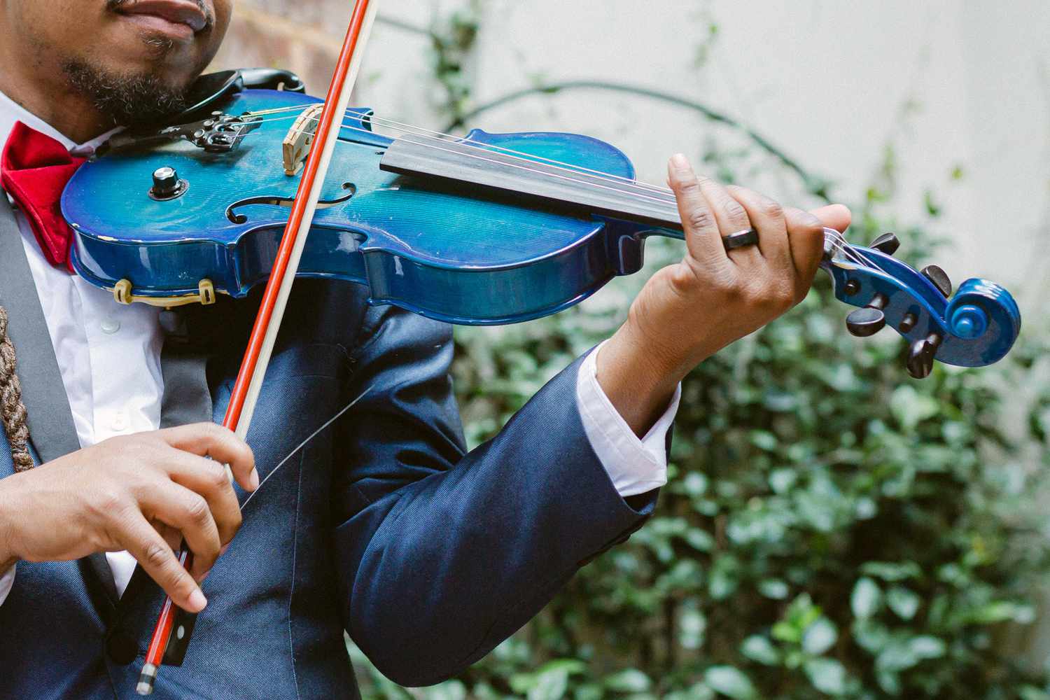 man playing blue violin for wedding