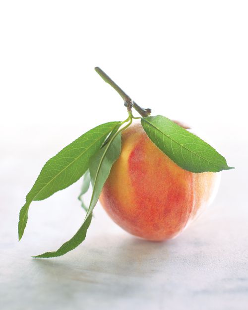 Peach with leaves on marble surface