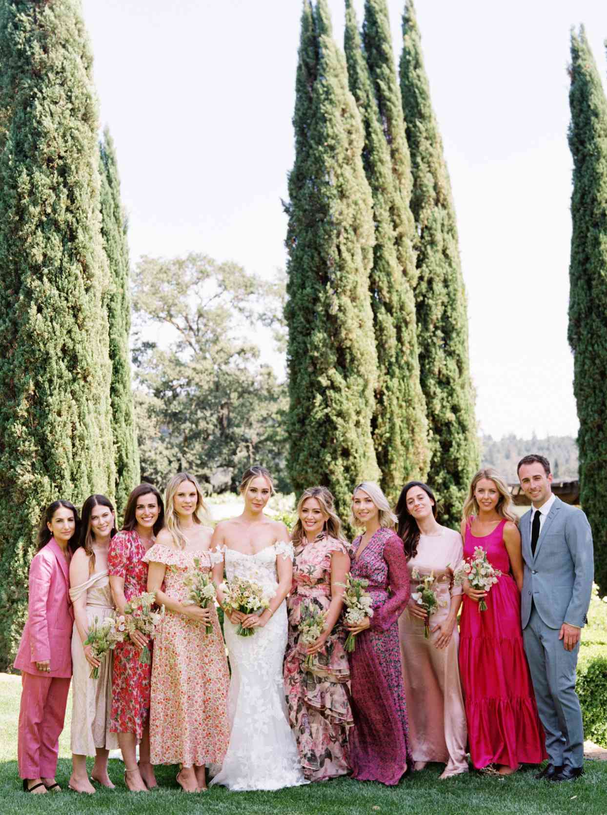 bridesmaids in pink floral apparel with bride in garden