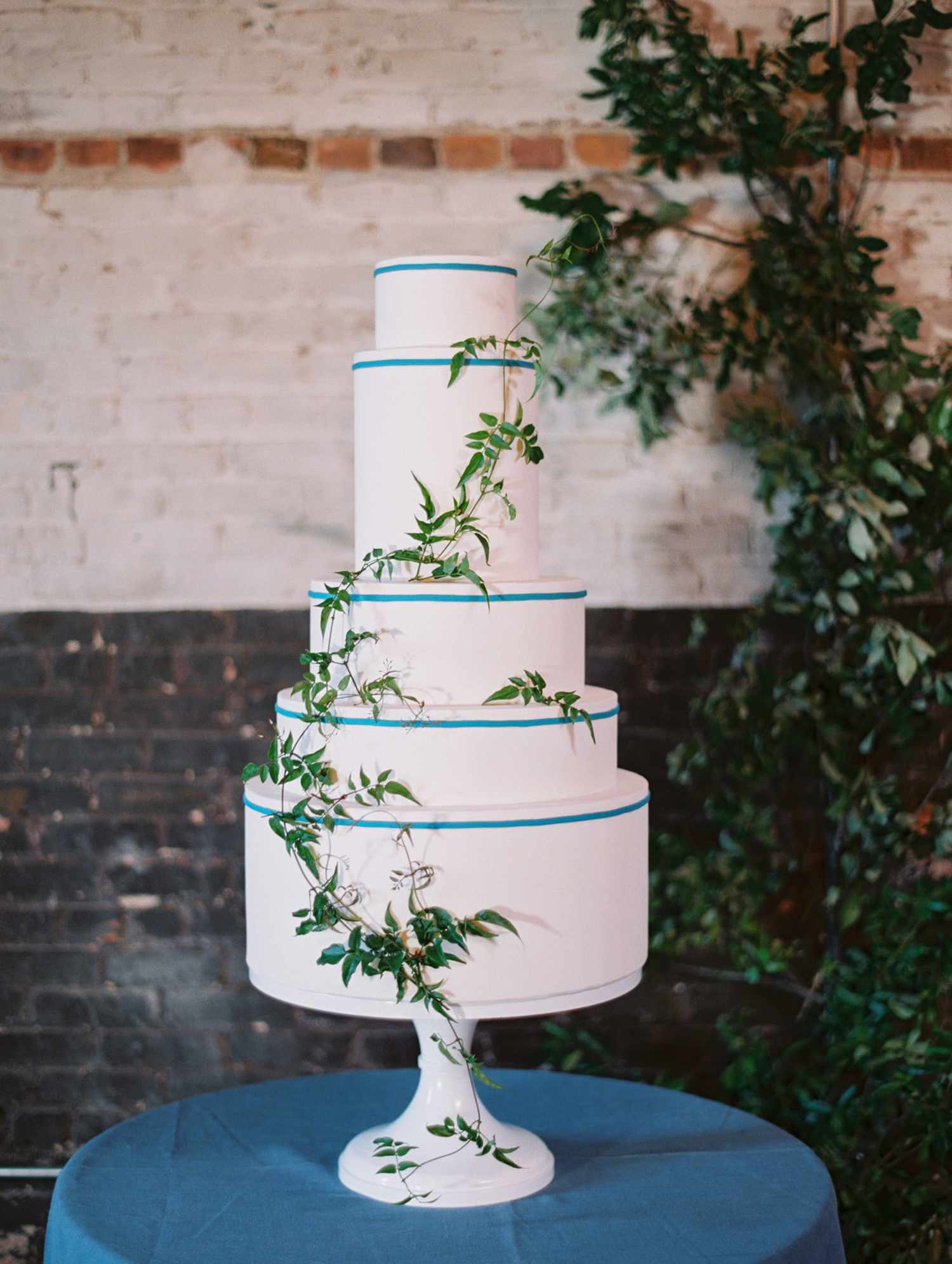 5-tier white wedding cake with greenery
