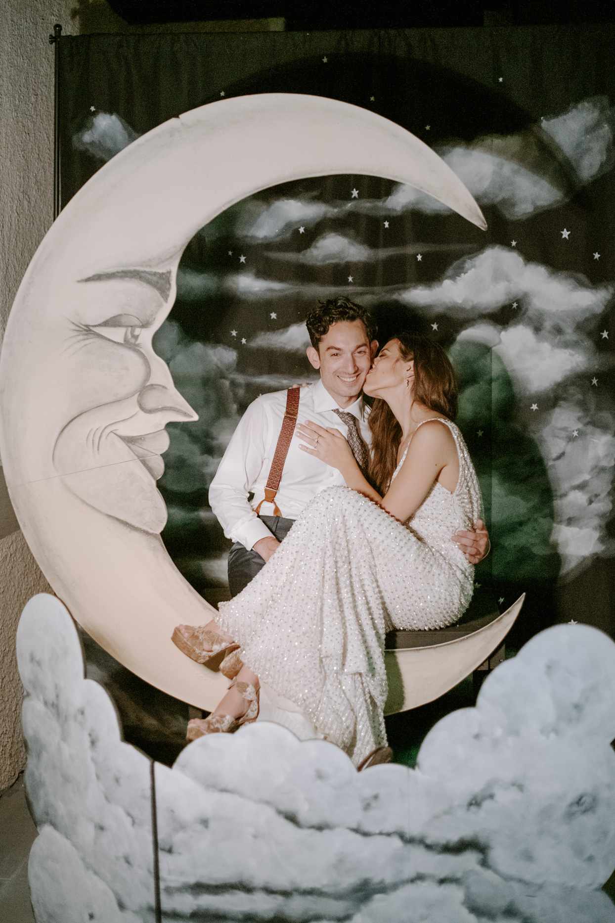 wedding couple posing together against moon backdrop