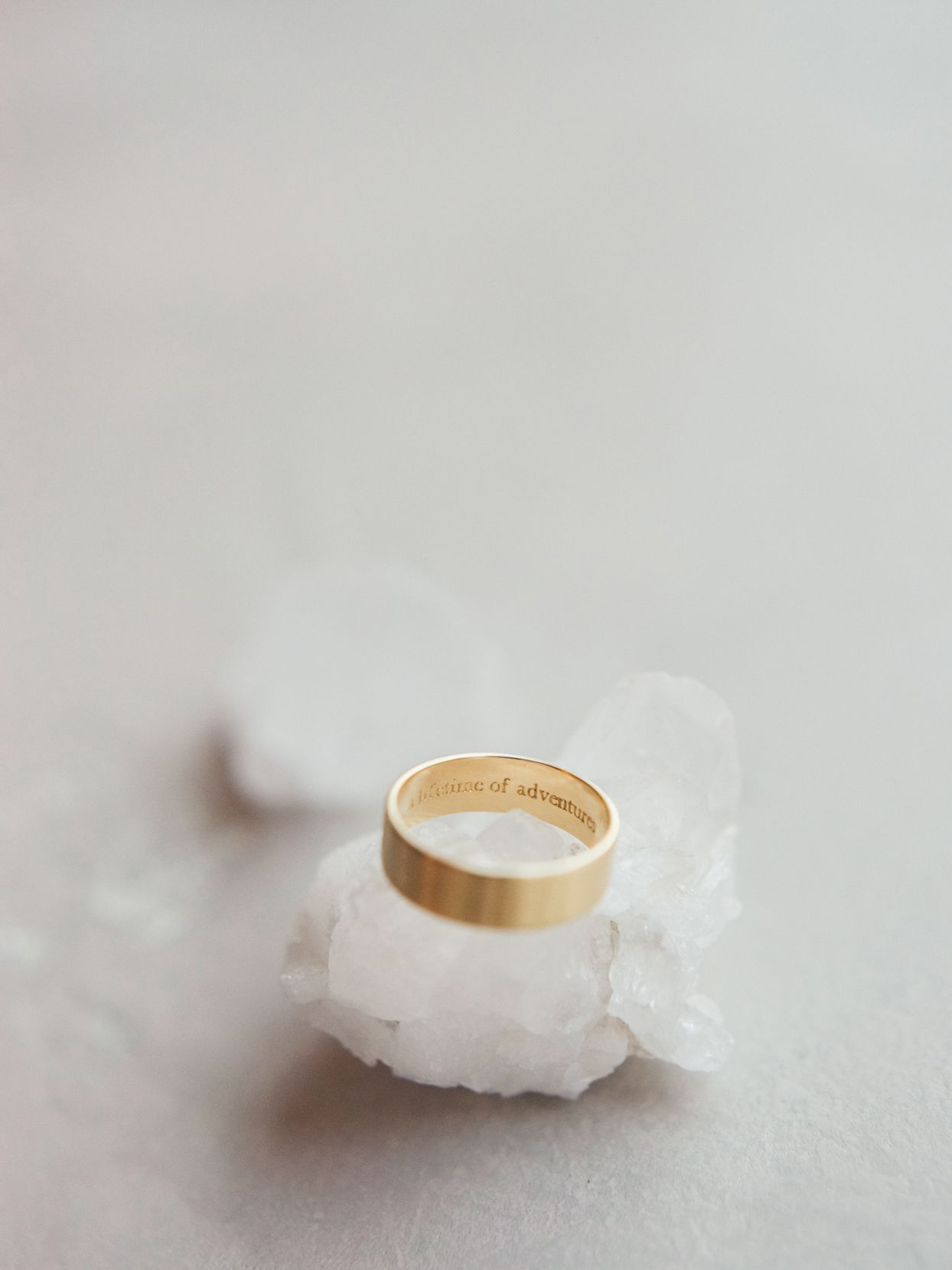 gold wedding band on white crystal
