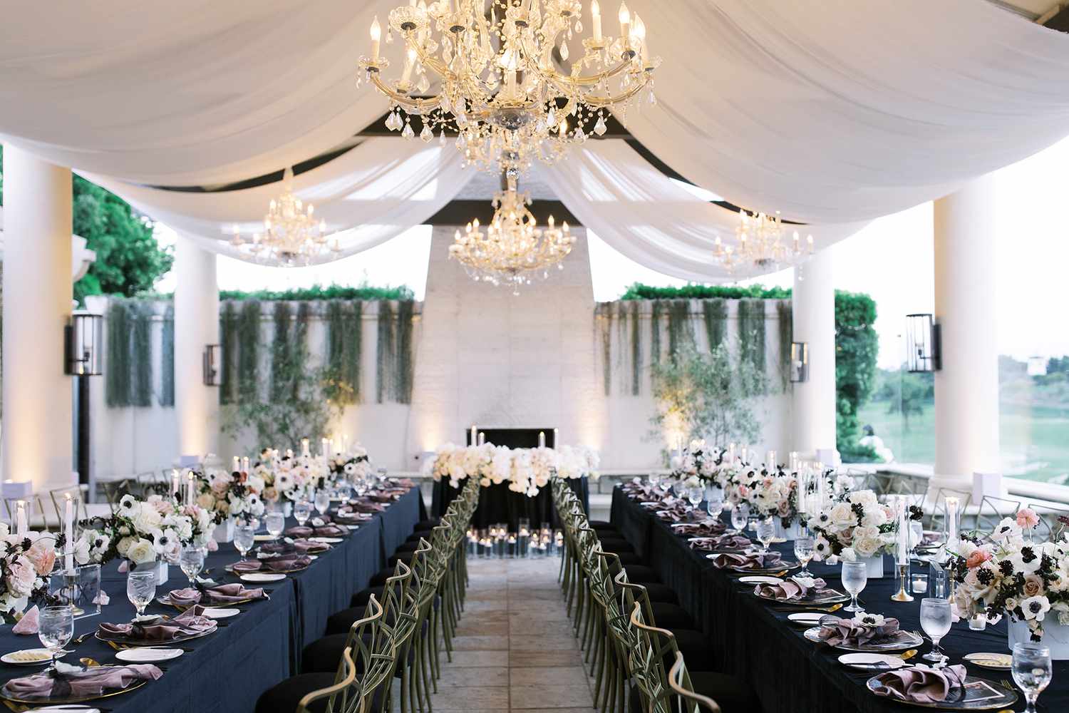 wedding reception with black velvet linens, ivory fabric, and chandeliers