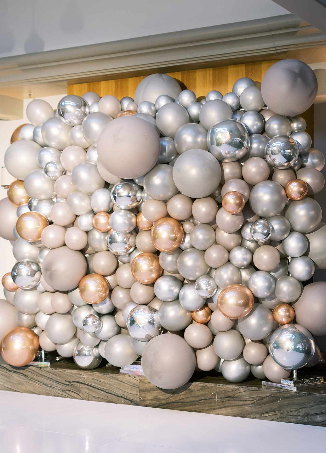 photo backdrop of silver and gold balloons for wedding reception