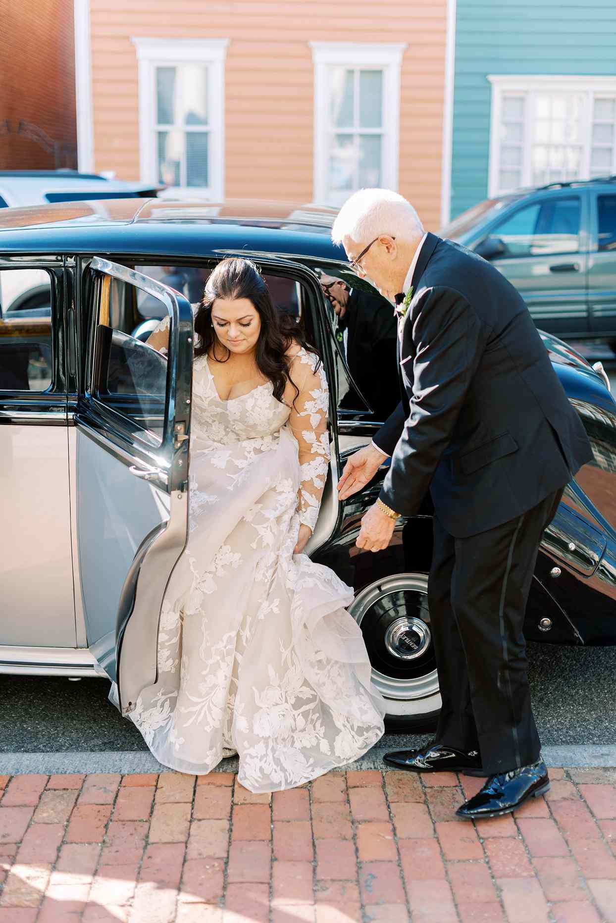 bride stepping out of car onto brick sidewalk
