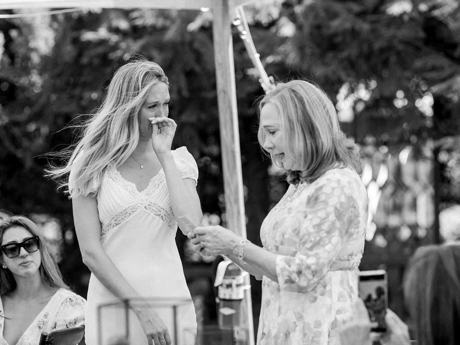 mother of the bride giving bridal shower speech next to bride crying