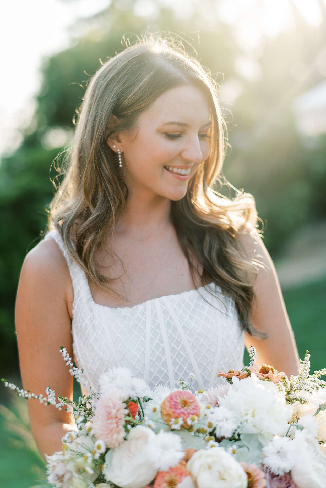 bride smiling holding floral wedding bouquet