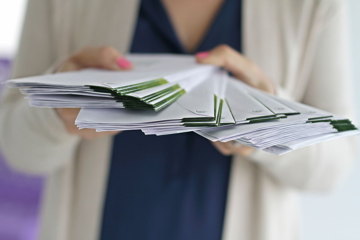 woman holding stack of letters fanned out