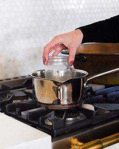 placing mason jar into pan on stove