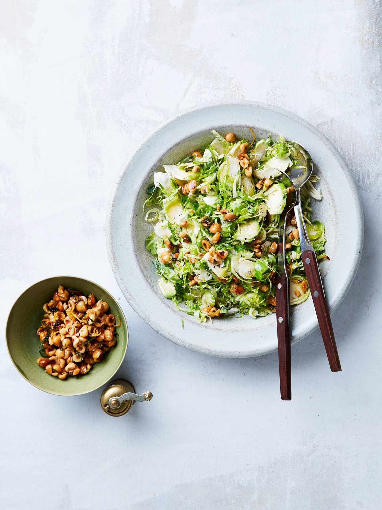 shredded brussels sprout salad with hazelnut crunch served in a white bowl