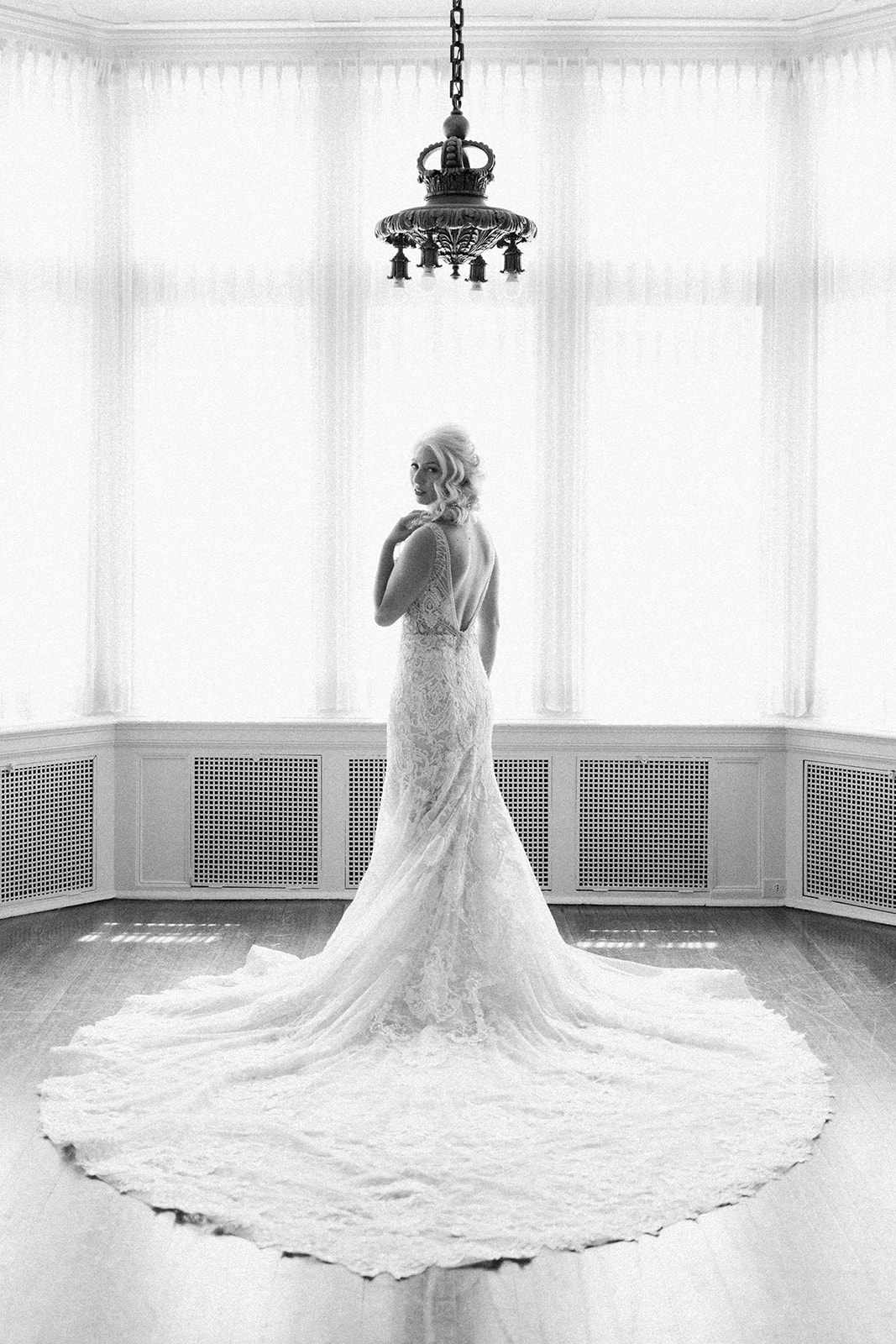 bride looking back over shoulder wearing long train plunging open back wedding dress
