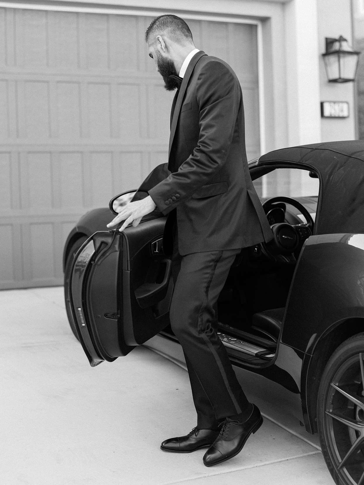 groom standing next to black vintage car