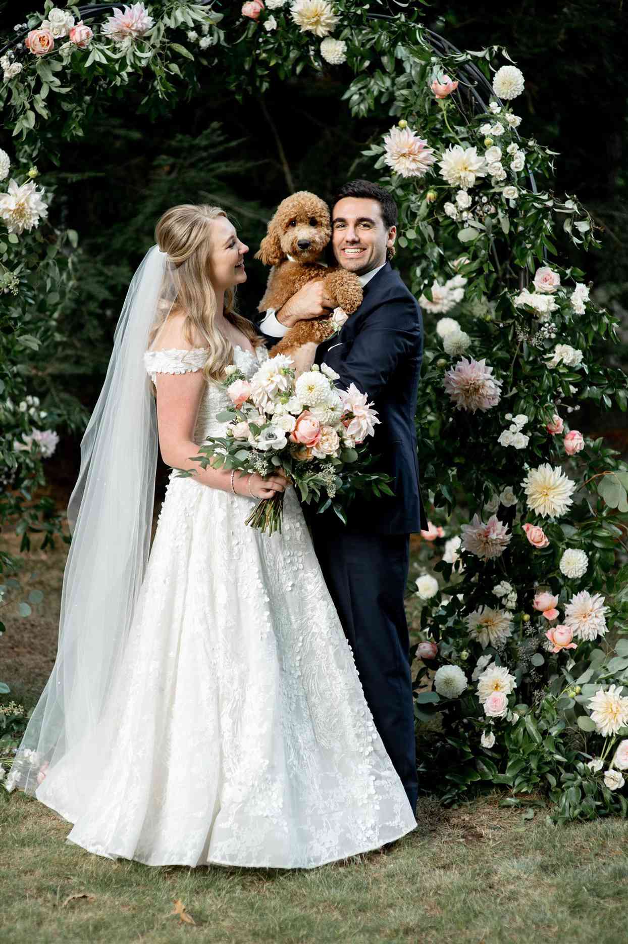 Bride and groom holding dog