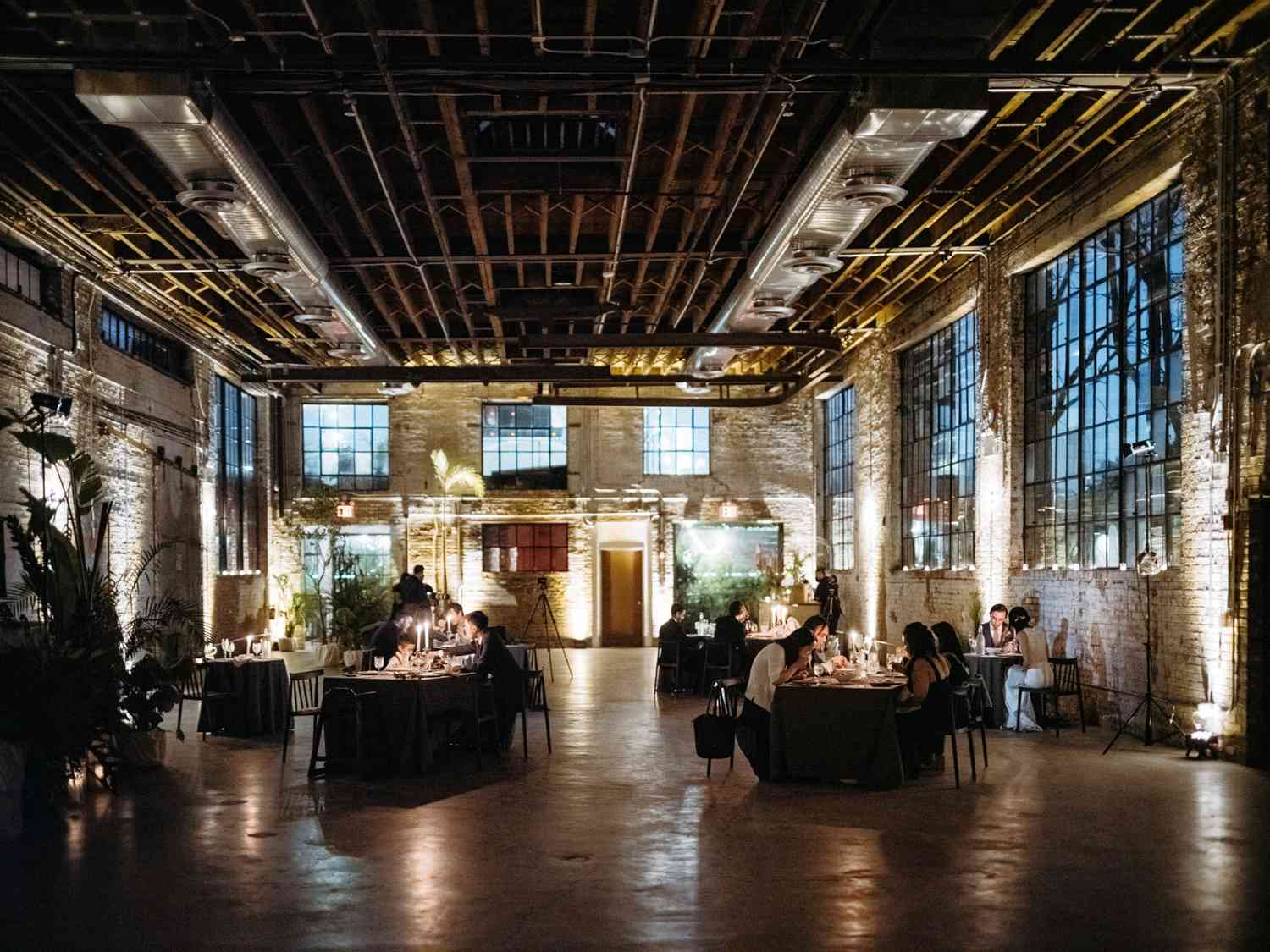 wide view of candle light wedding reception in brooklyn warehouse