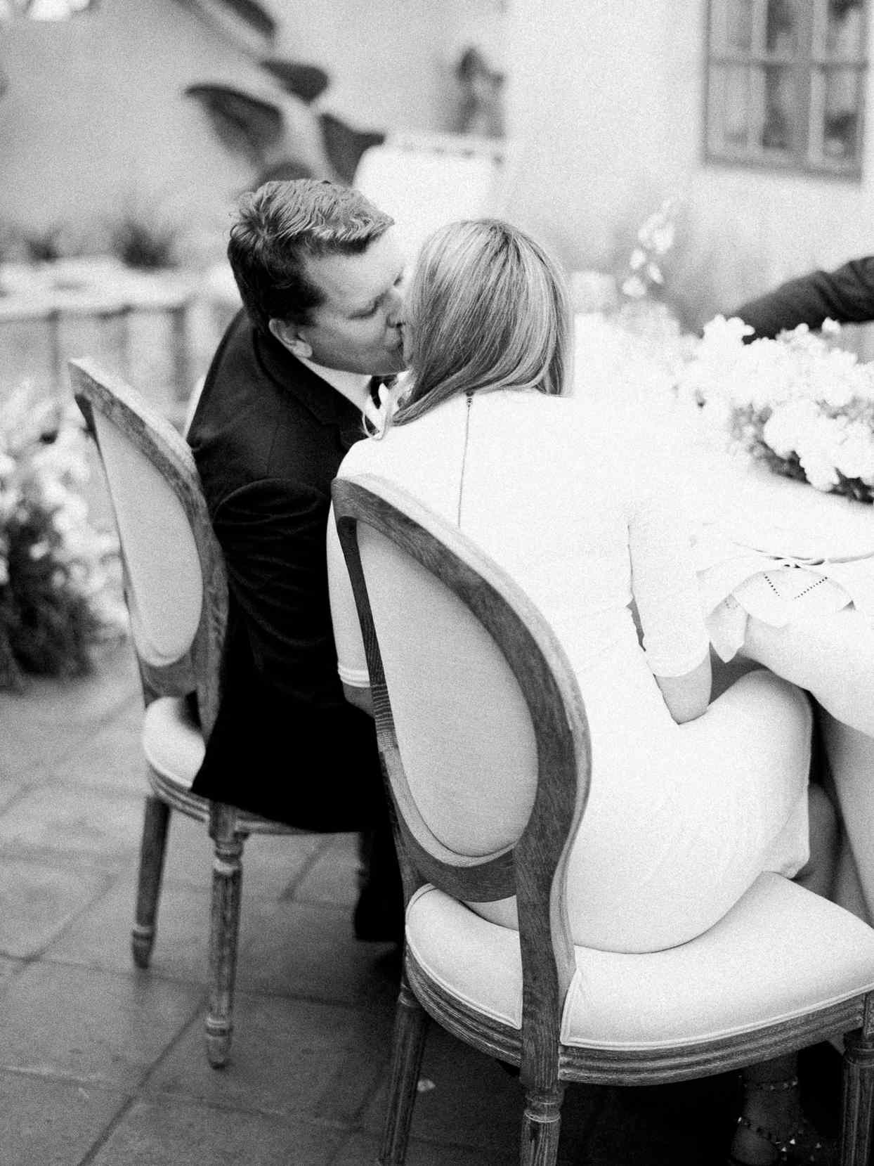 wedding couple kissing at table at reception