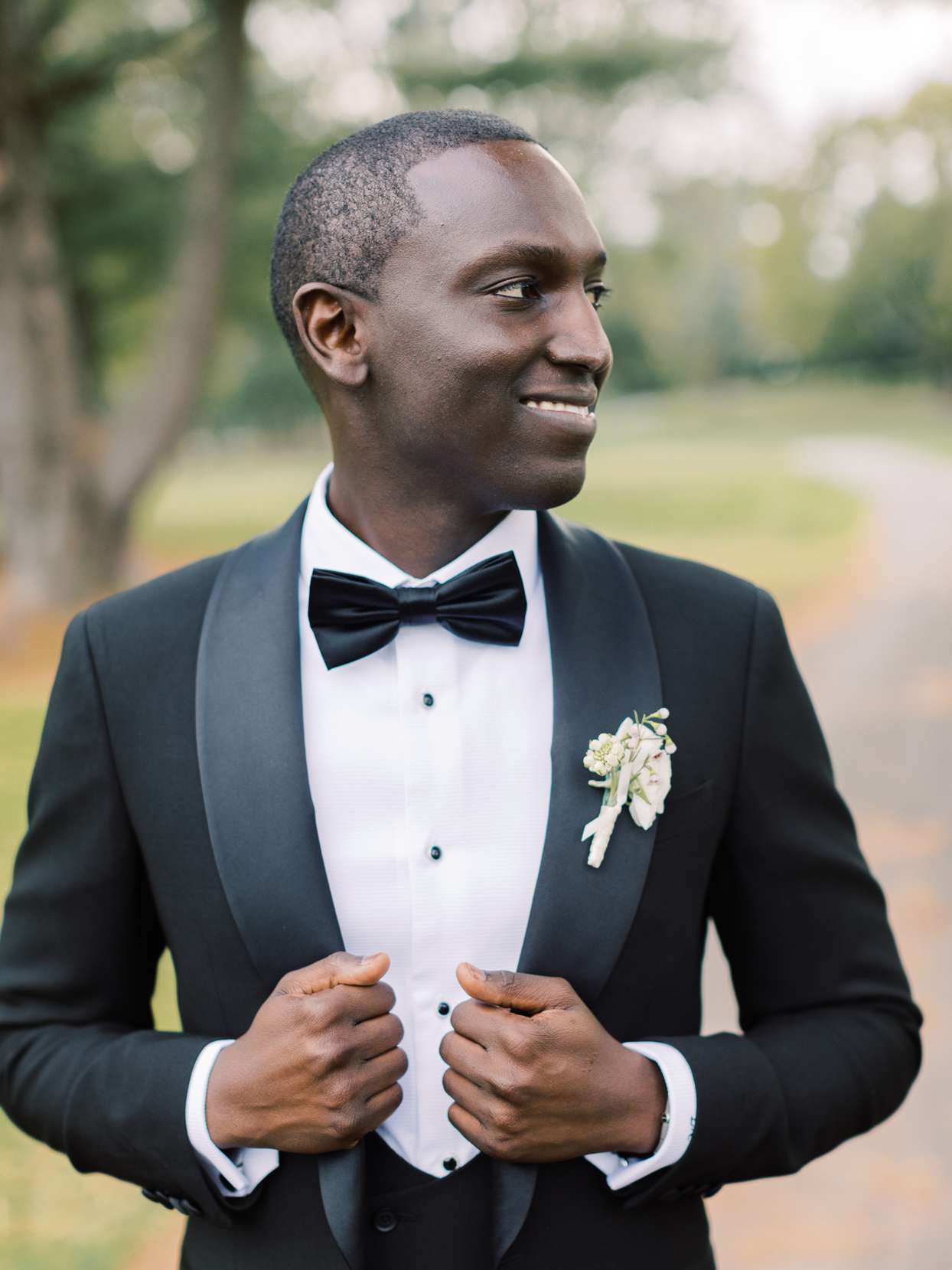 groom in black tux with white floral boutonniere