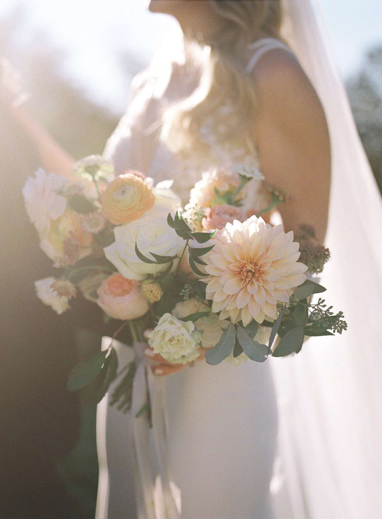 bride holding pastel floral wedding bouquet