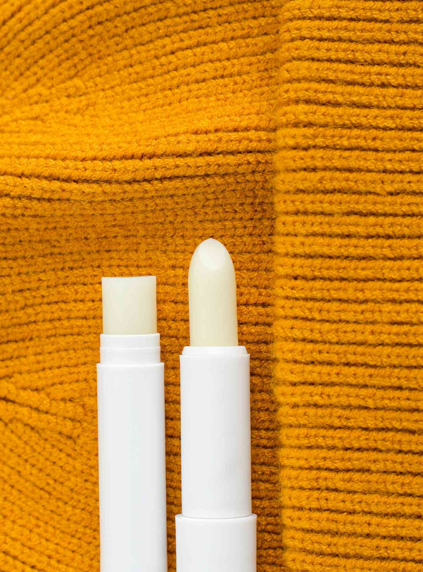 two lips balm sticks on knit background