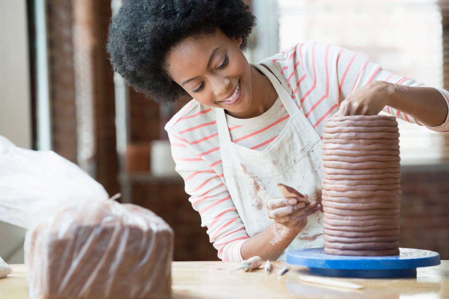 woman sculpting clay vase