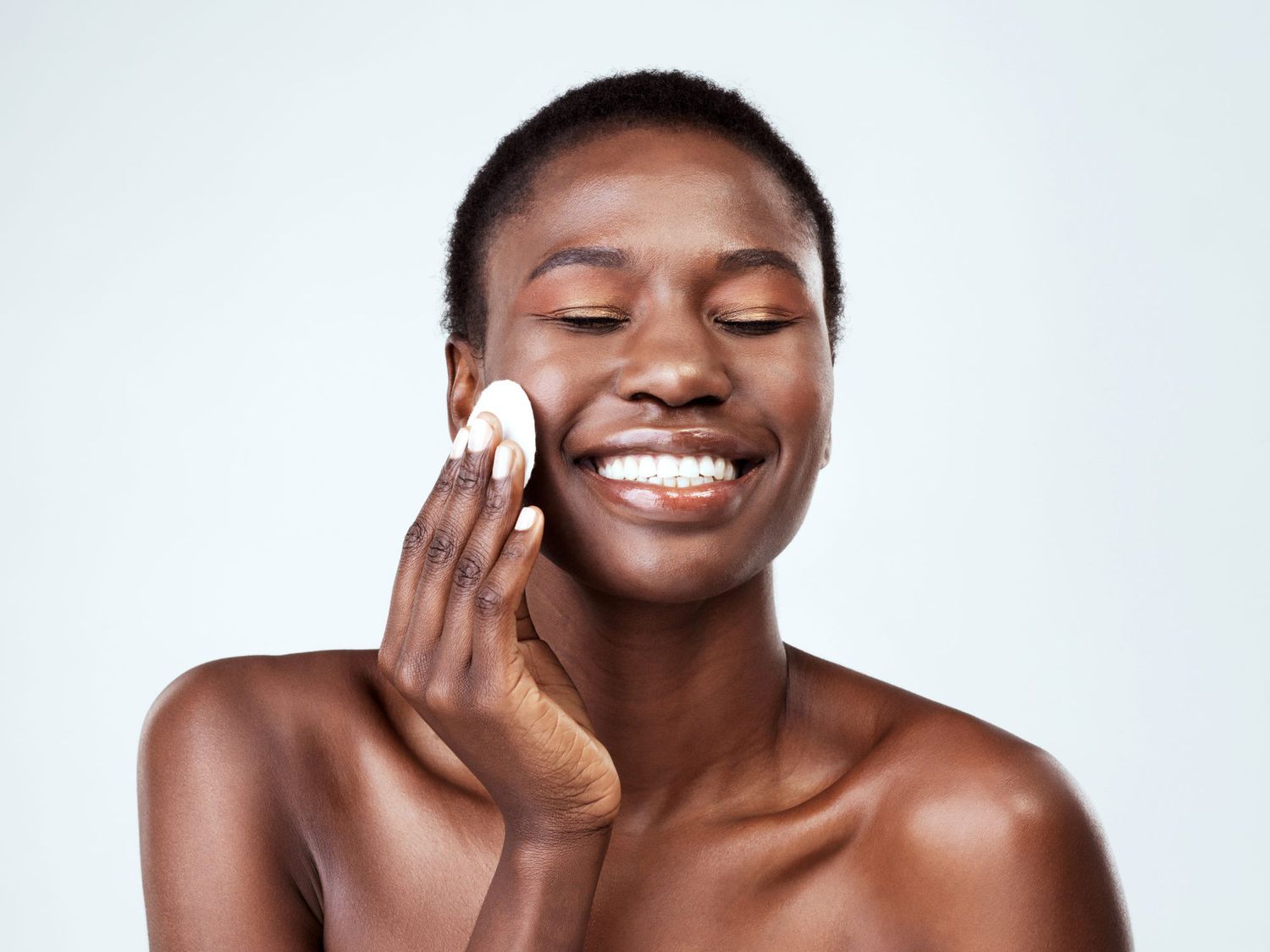 woman using cotton pad on face