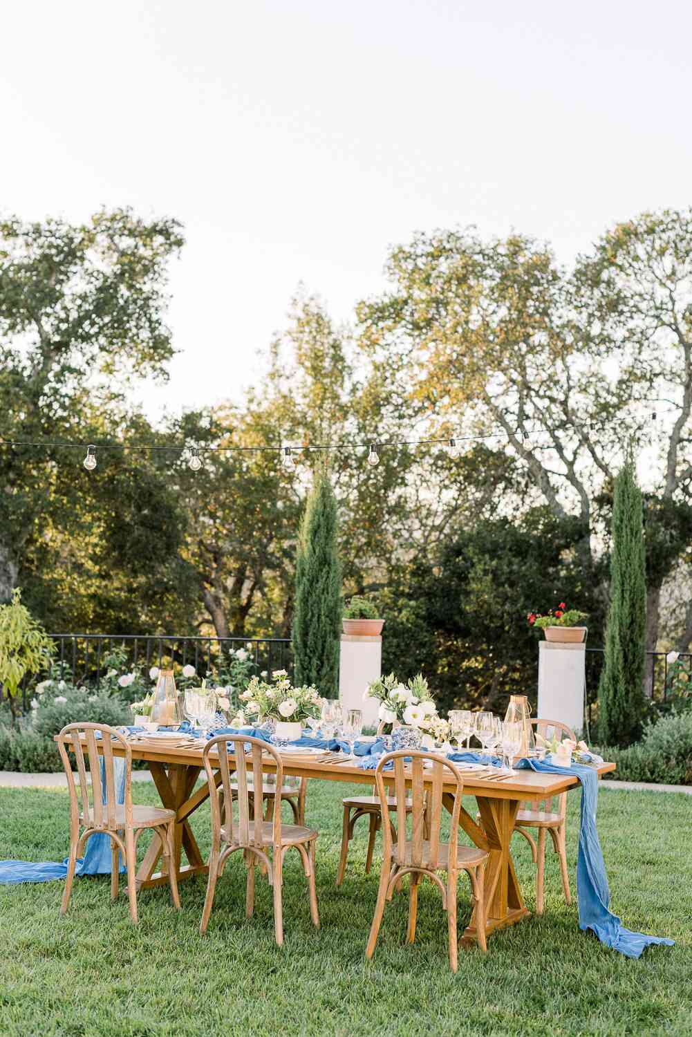 table set for six with flowers and blue linens