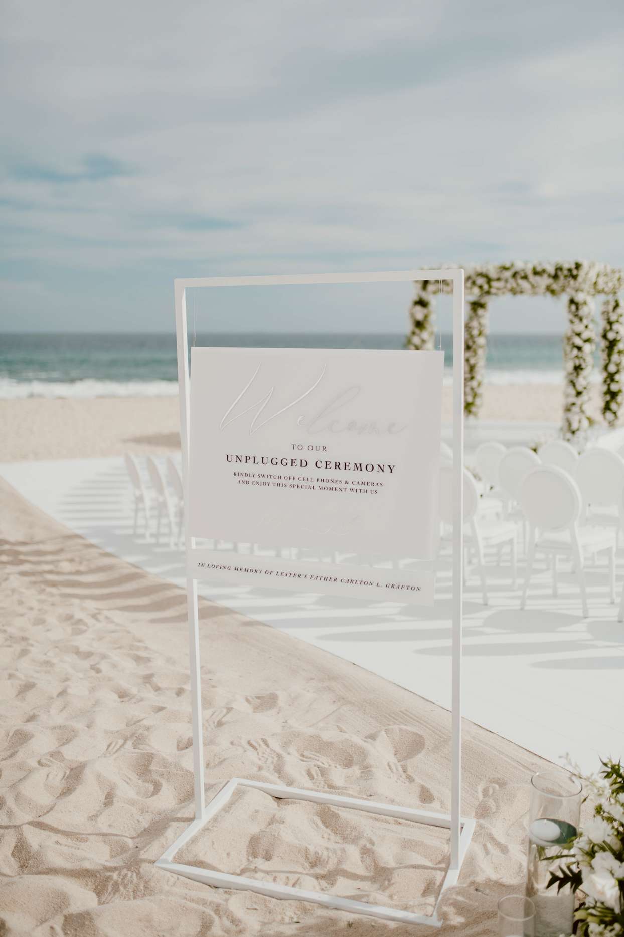 elegant white wedding sign for unplugged ceremony on beach