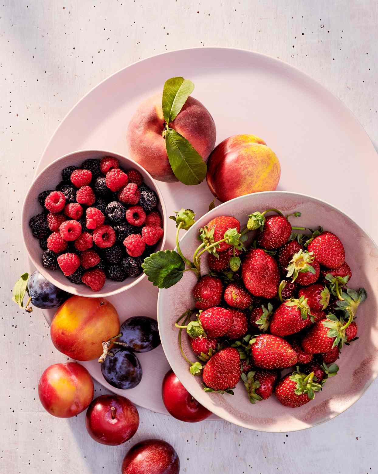 fruit filled bowls on matching platter