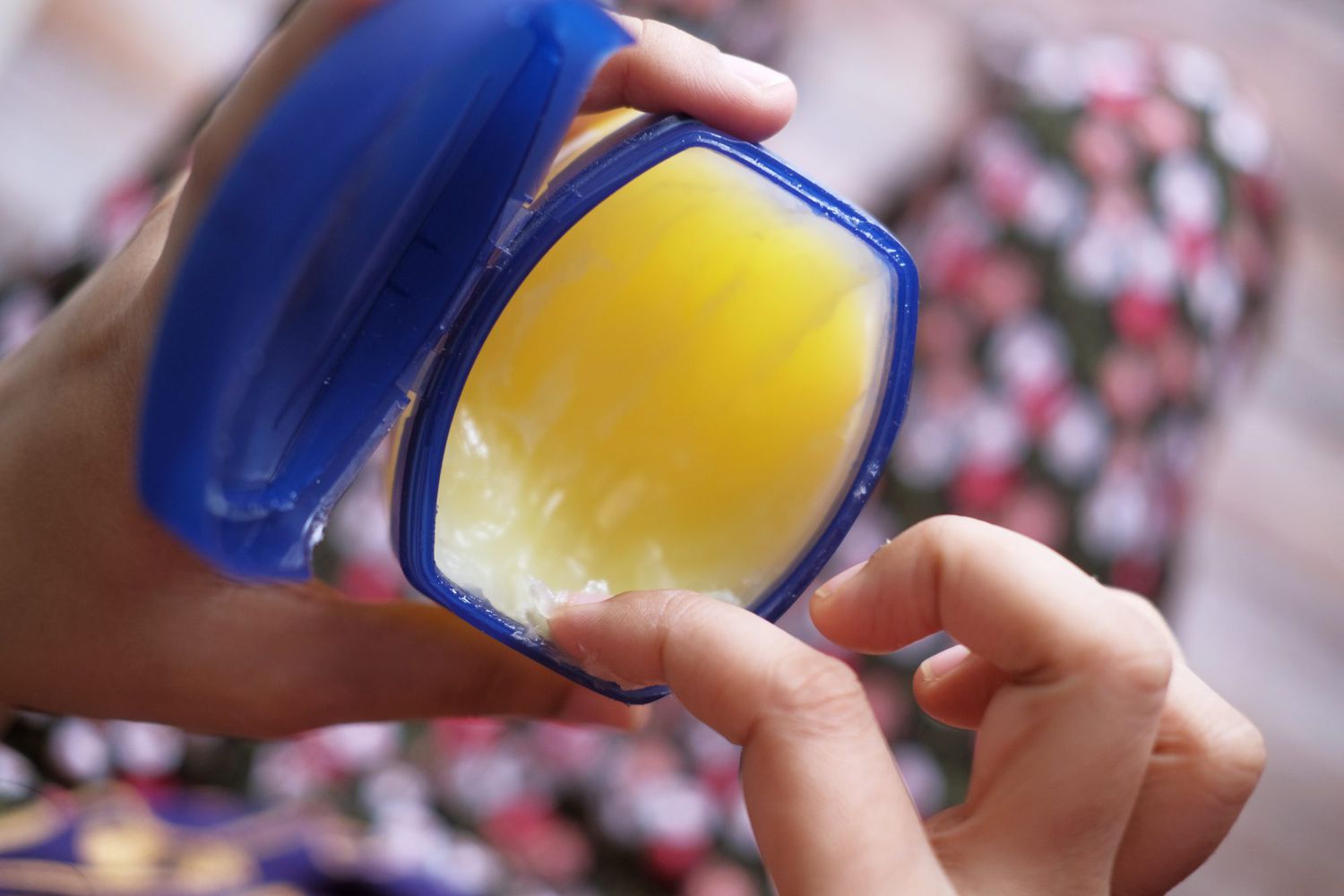 scooping petroleum jelly from jar